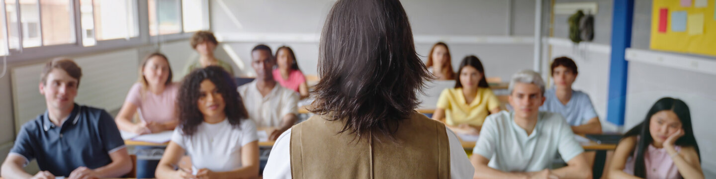 Education degrees header - Teacher stands in front of classroom